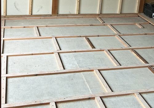 畳を撤去し根太を組んで床下地を施工している様子